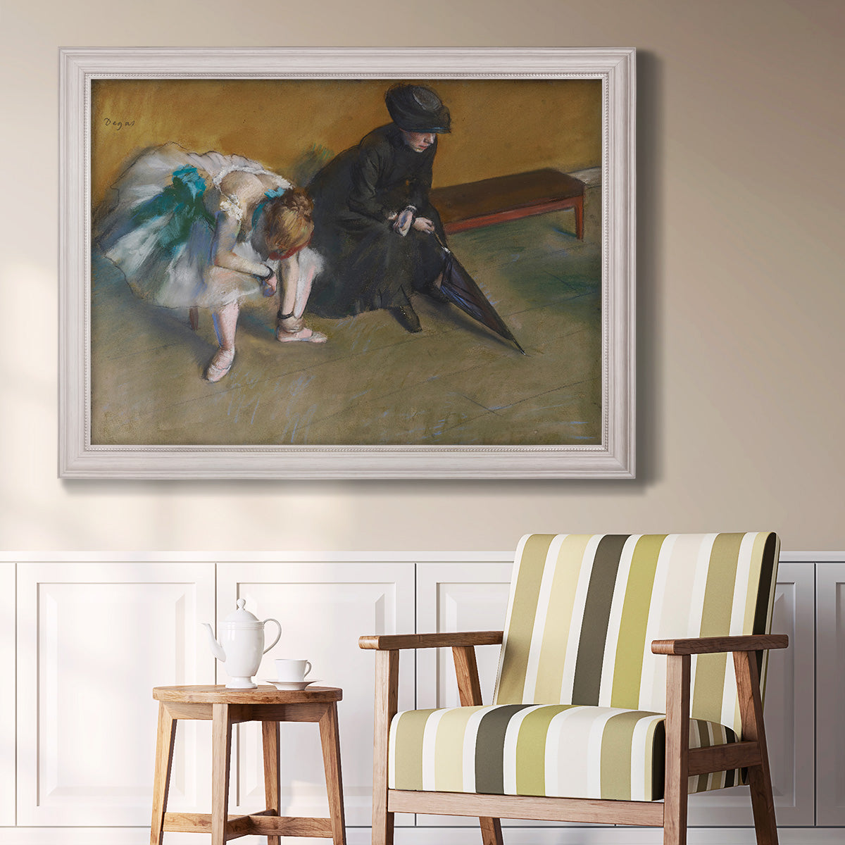 Impressionist portrait of a seated woman by Edgar Degas in an ornate weathered white frame displayed in a light-toned interior setting.