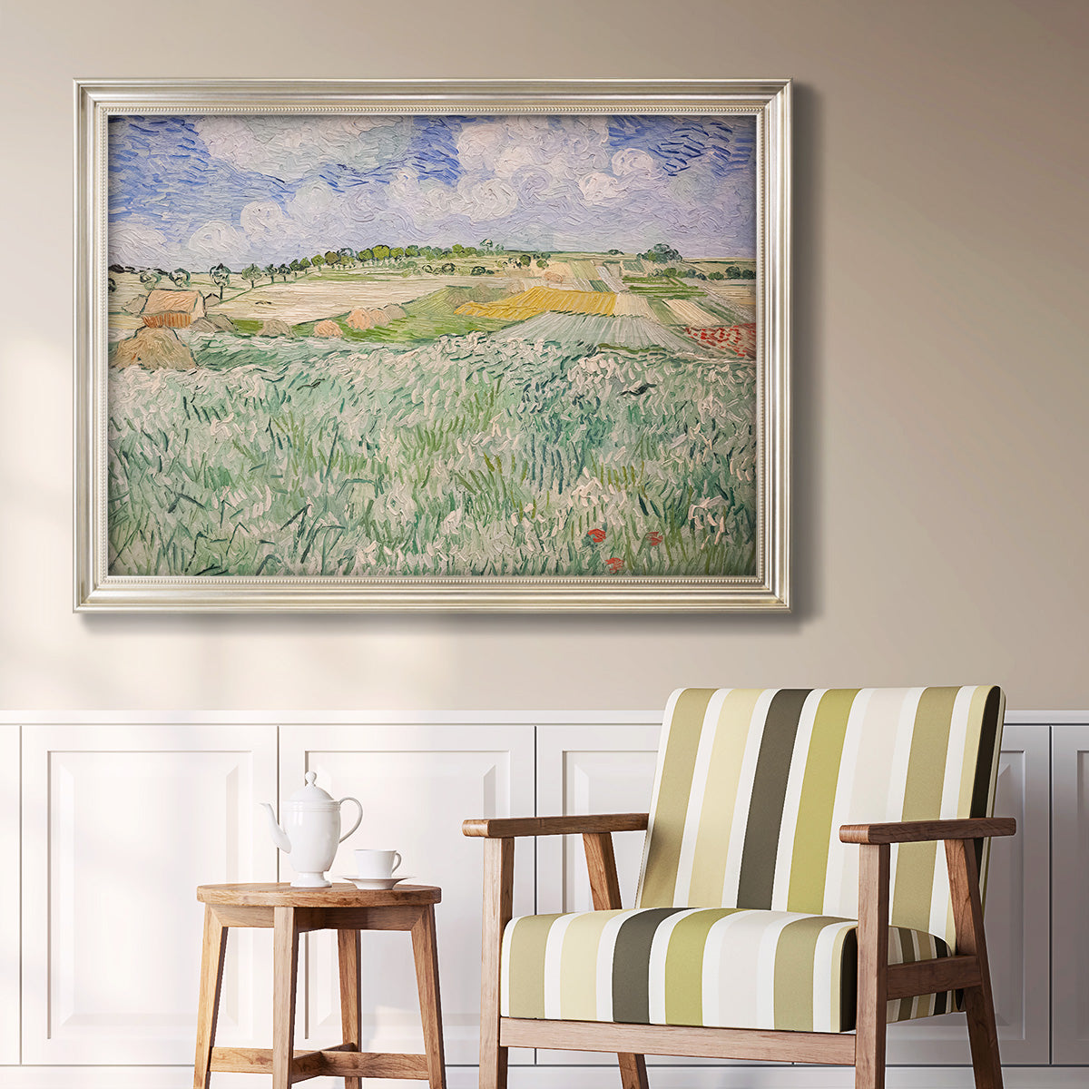 Impressionist countryside landscape near Auvers by Vincent van Gogh in an ornate champagne frame displayed in a light-toned interior setting.