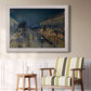Impressionist nighttime Paris street scene by Camille Pissarro in an ornate weathered white frame displayed in a light-toned interior setting.