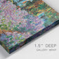 Close-up view of wrapped canvas corner featuring blooming irises in garden bed.