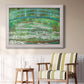 Impressionist garden scene with Japanese bridge and water lilies by Claude Monet in an ornate weathered white frame displayed in a light-toned interior setting.