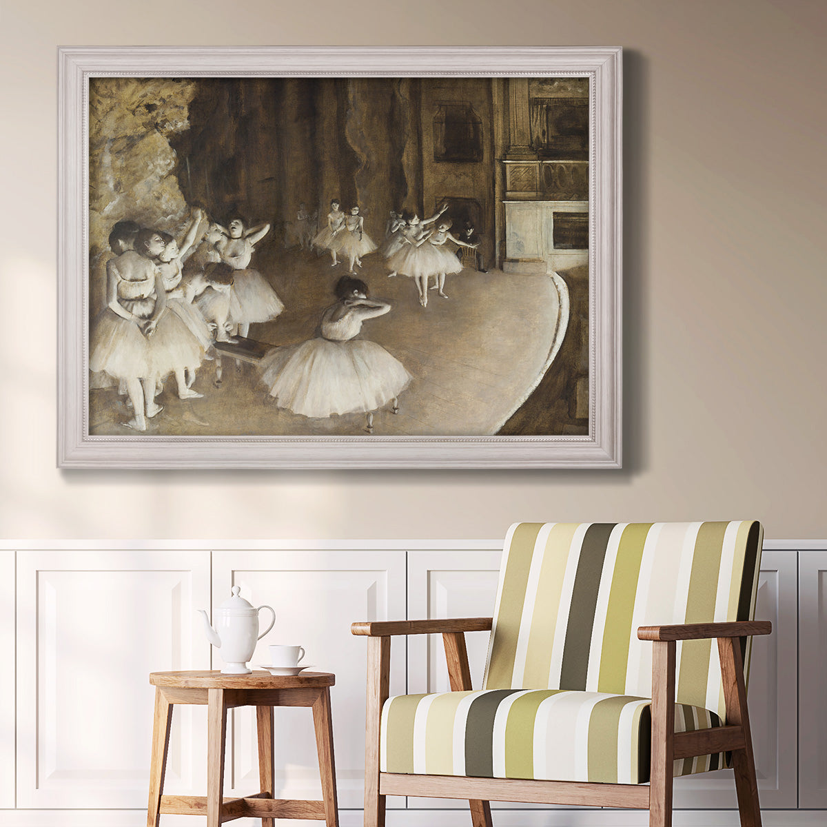 Impressionist ballet rehearsal scene by Edgar Degas in an ornate weathered white frame displayed in a light-toned interior setting.