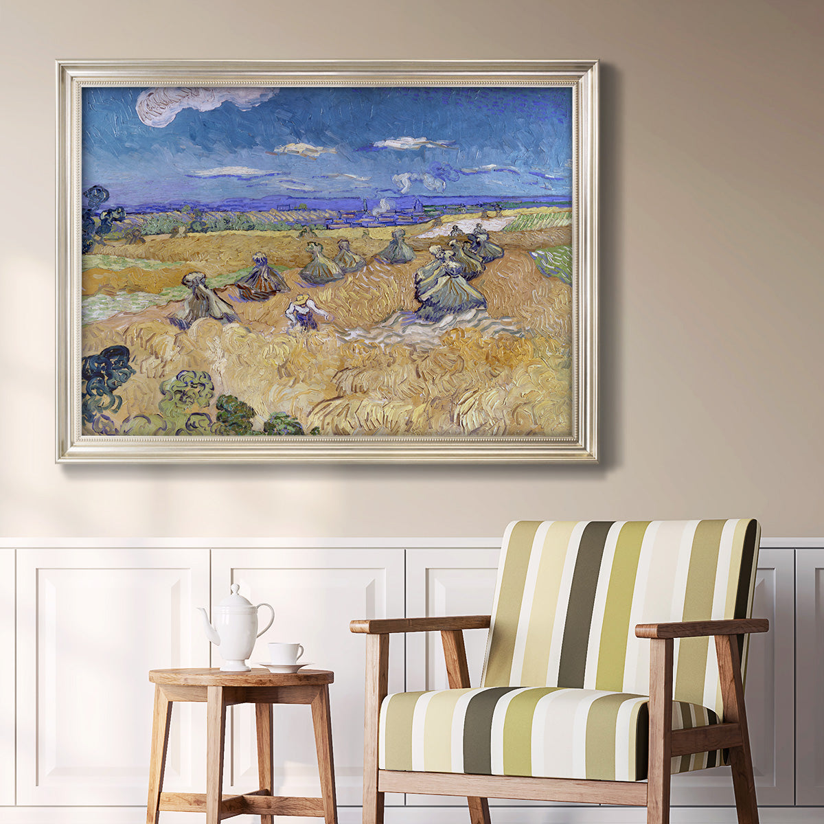 Impressionist wheat harvest scene by Vincent van Gogh in an ornate champagne frame displayed in a light-toned interior setting.