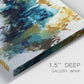 Close-up view of wrapped canvas corner featuring teal abstract paint splatter.
