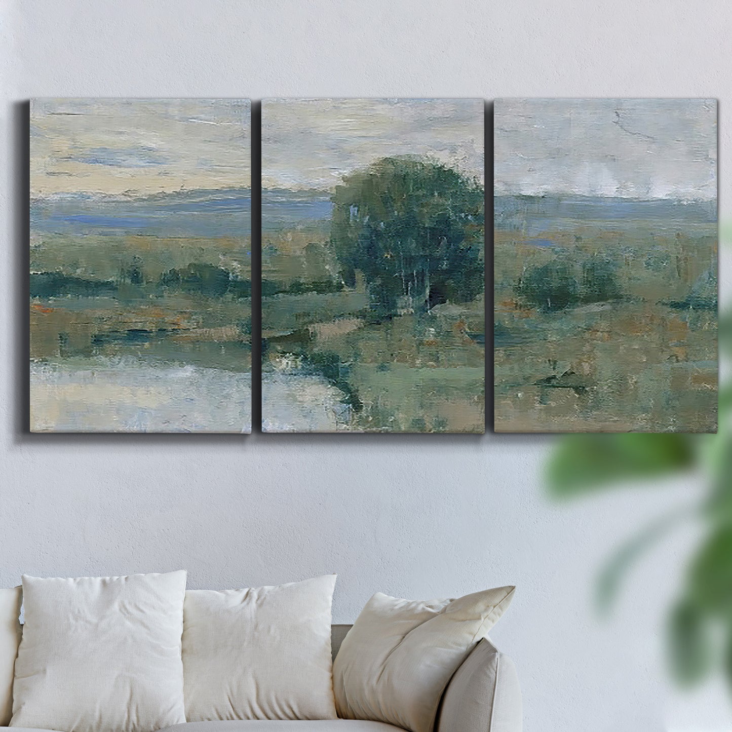 Three-panel canvas wall art featuring riverbank landscape with reflections, displayed in a living room above a sofa.
