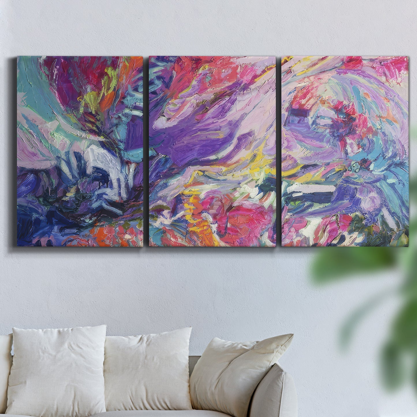 Three-panel canvas wall art featuring expressive abstract with layered color, displayed in a living room above a sofa.