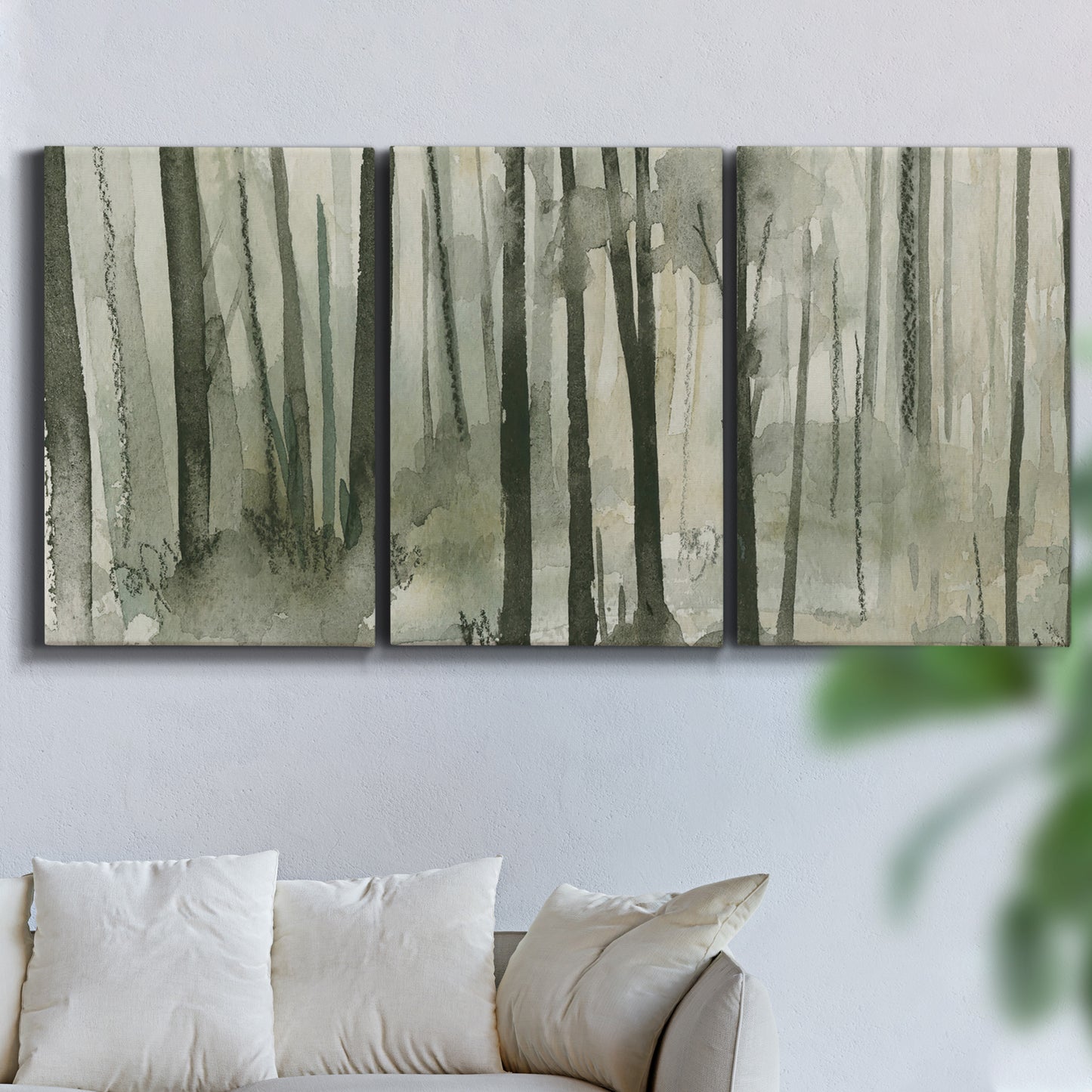 Three-panel canvas wall art featuring wooded forest path watercolor, displayed in a living room above a sofa.