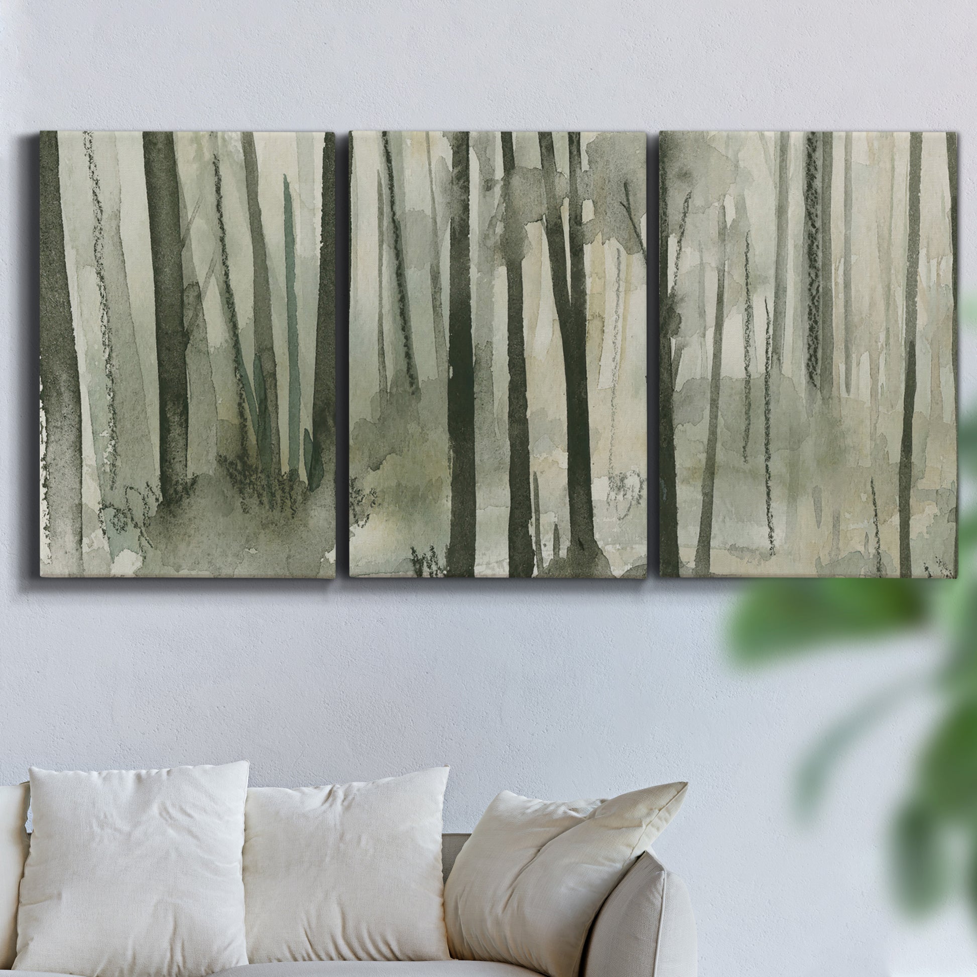 Three-panel canvas wall art featuring wooded forest path watercolor, displayed in a living room above a sofa.