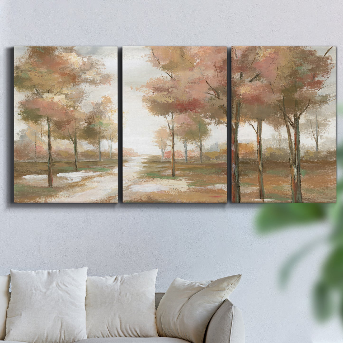 Three-panel canvas wall art featuring soft pastel park landscape scene, displayed in a living room above a sofa.