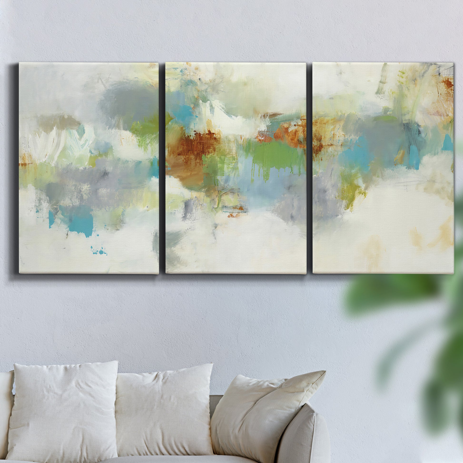 Three-panel canvas wall art featuring abstract suggestion of discovery, displayed in a living room above a sofa.