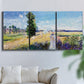 Three-panel canvas wall art featuring riverside path with figures, displayed in a living room above a sofa.