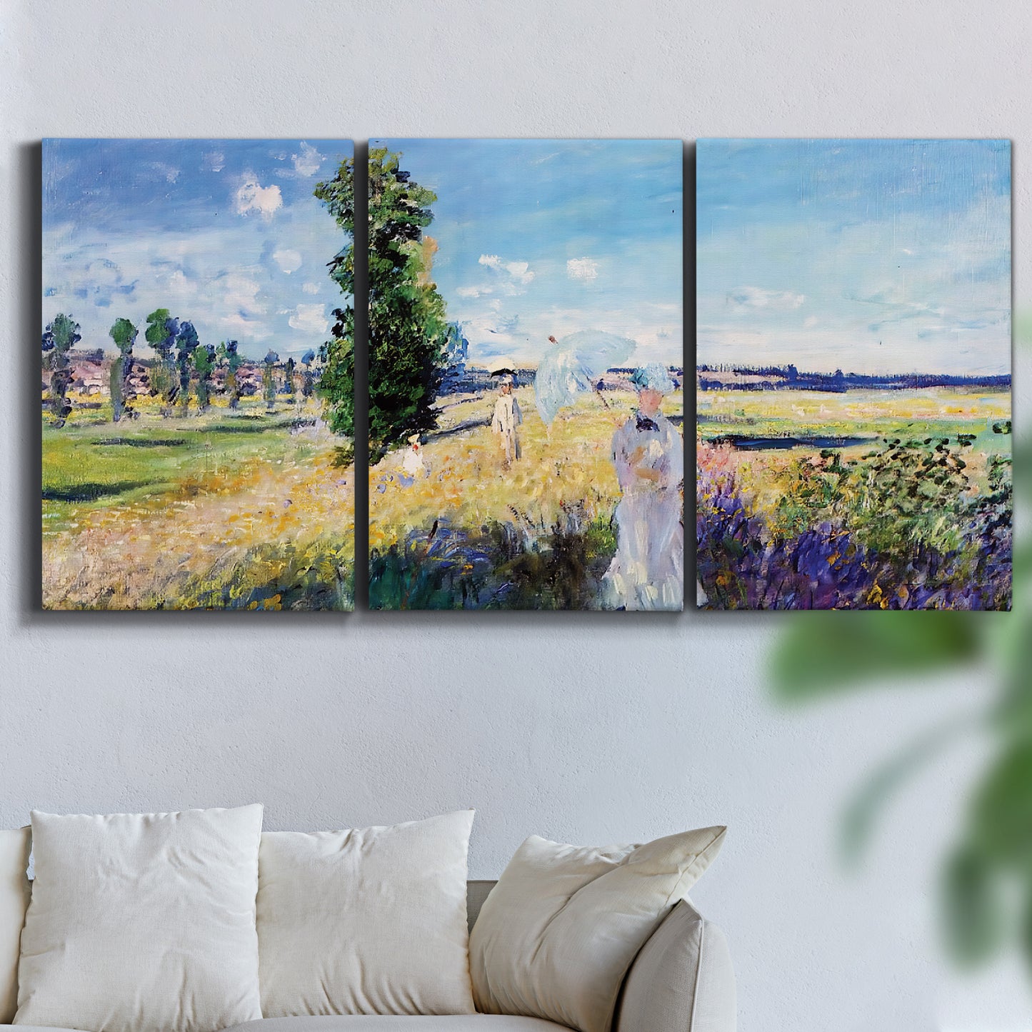 Three-panel canvas wall art featuring riverside path with figures, displayed in a living room above a sofa.