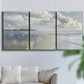 Three-panel canvas wall art featuring endless beach meeting ocean horizon, displayed in a living room above a sofa.