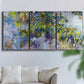 Three-panel canvas wall art featuring cascading purple wisteria blooms, displayed in a living room above a sofa.