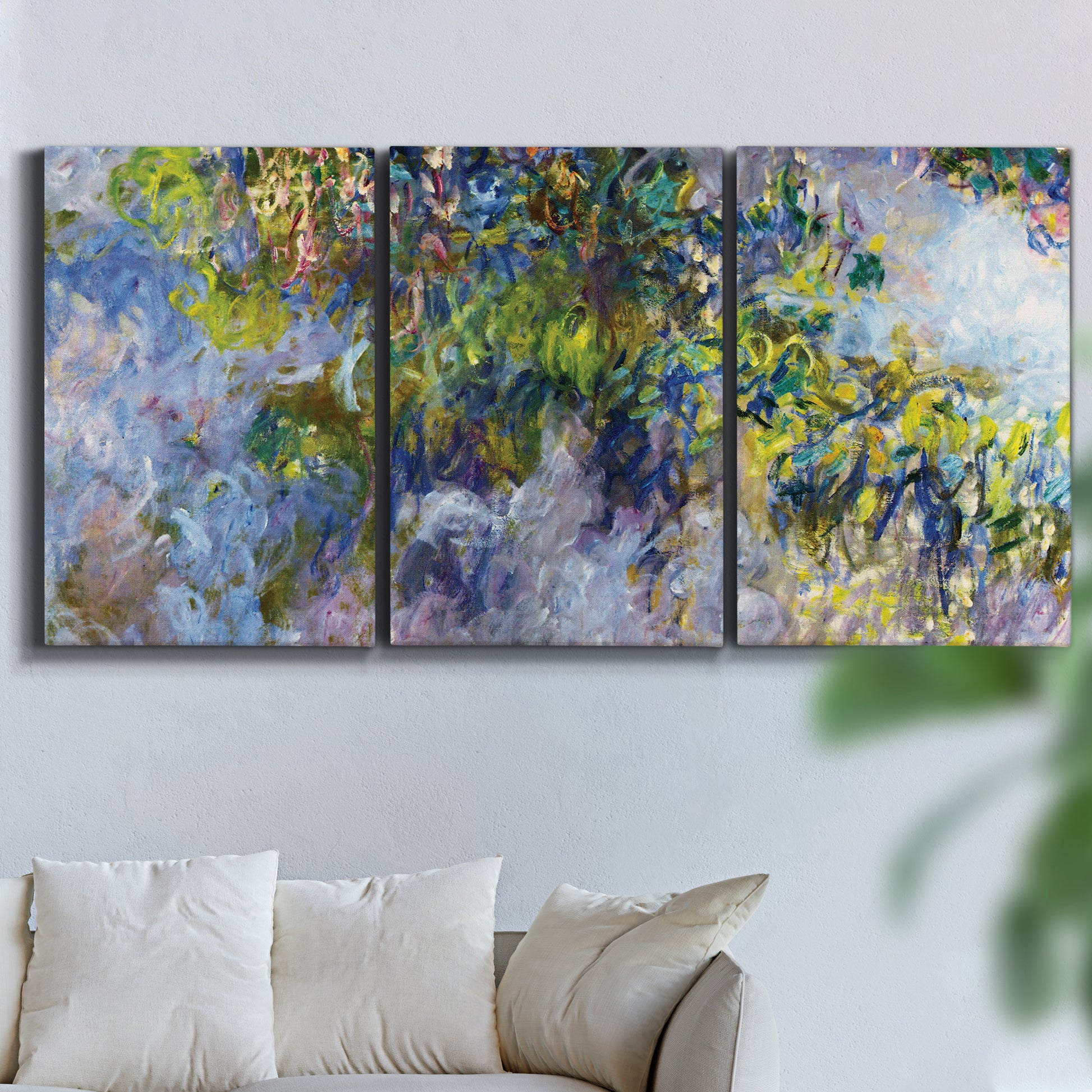 Three-panel canvas wall art featuring cascading purple wisteria blooms, displayed in a living room above a sofa.