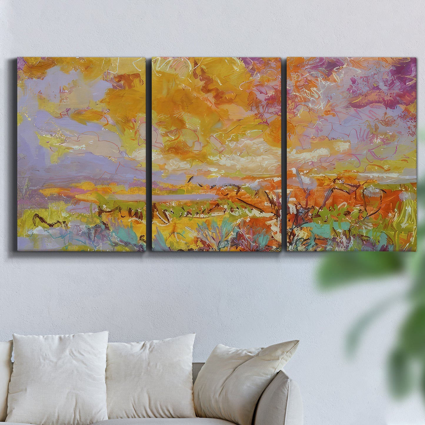 Three-panel canvas wall art featuring abstract meadow inspired color fields, displayed in a living room above a sofa.
