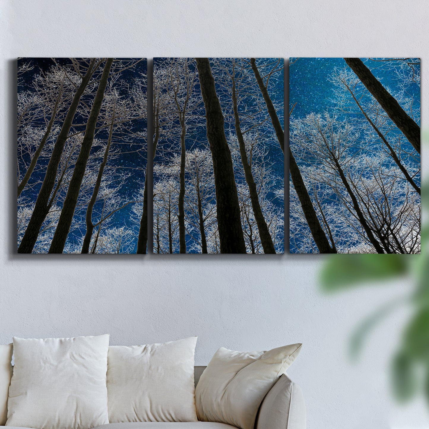 Three-panel canvas wall art featuring night landscape silhouette photography, displayed in a living room above a sofa.