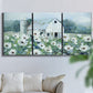 Three-panel canvas wall art featuring pastoral farmland with open fields, displayed in a living room above a sofa.