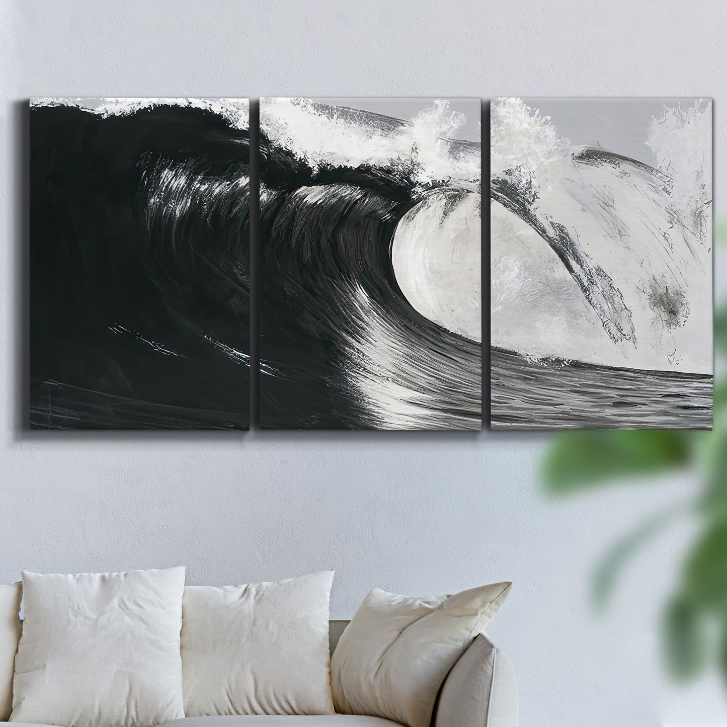 Three-panel canvas wall art featuring black and white crashing ocean waves, displayed in a living room above a sofa.