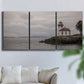 Three-panel canvas wall art featuring lighthouse watching over coastline, displayed in a living room above a sofa.