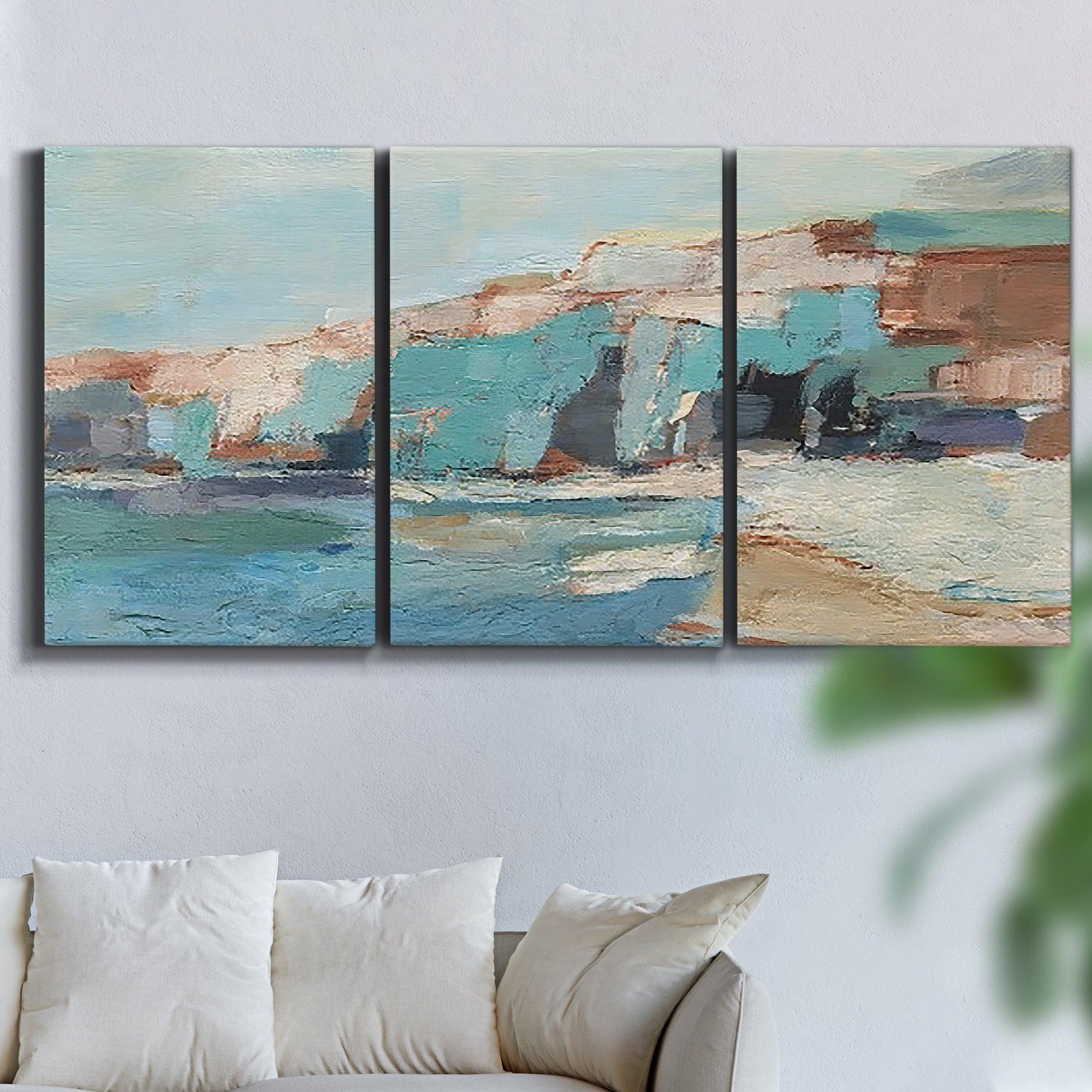 Three-panel canvas wall art featuring coastal shoreline with soft waves, displayed in a living room above a sofa.