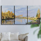 Three-panel canvas wall art featuring river flowing past village, displayed in a living room above a sofa.