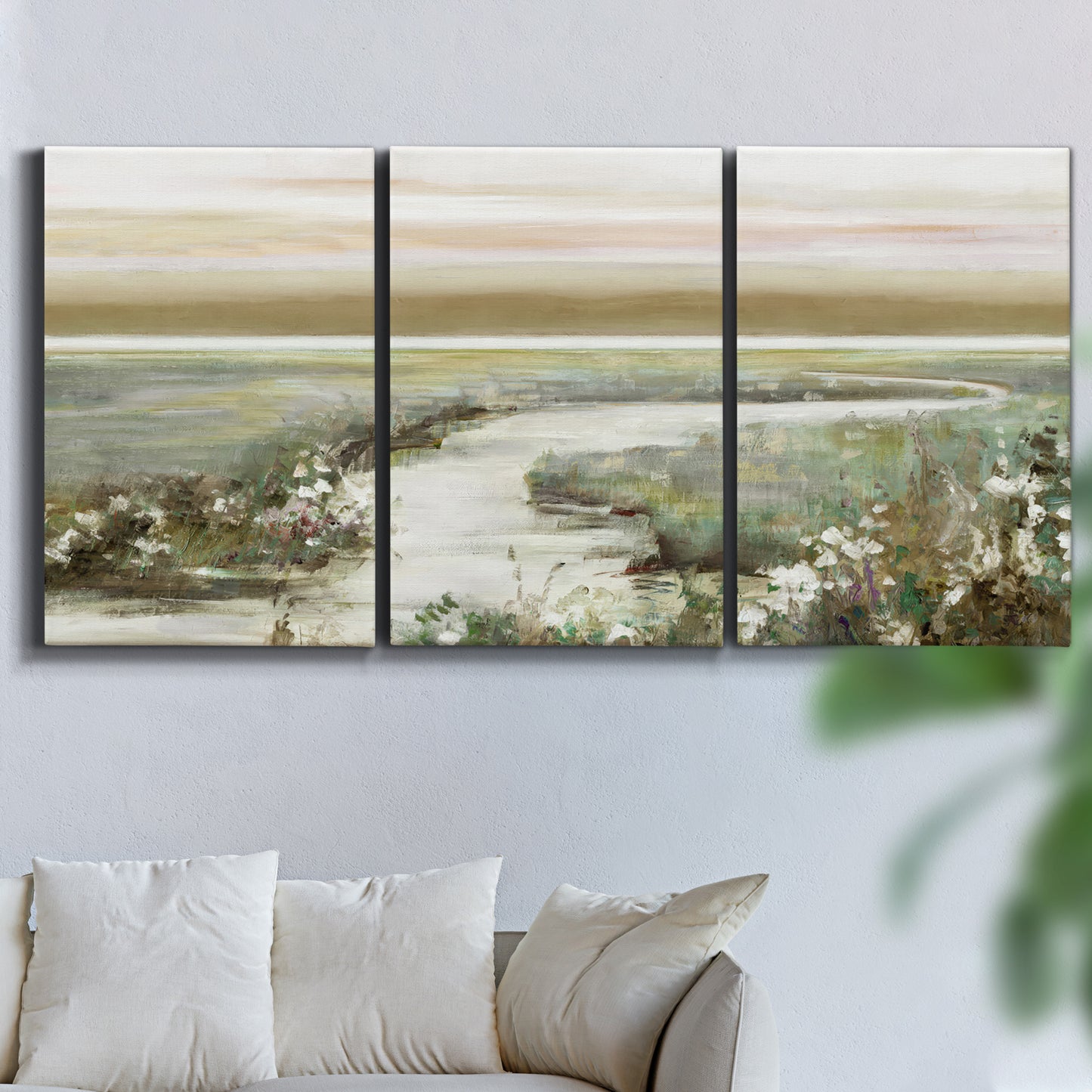 Three-panel canvas wall art featuring pastoral fields under soft sunrise, displayed in a living room above a sofa.