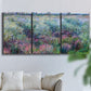 Three-panel canvas wall art featuring flowered riverbank with trees, displayed in a living room above a sofa.