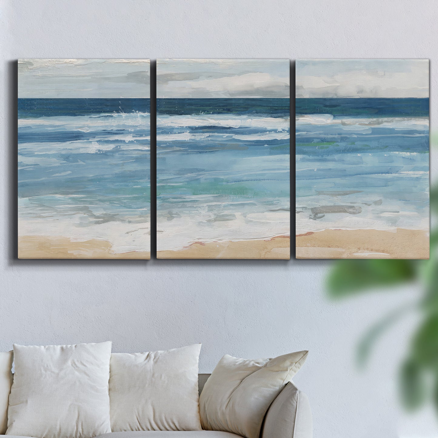 Three-panel canvas wall art featuring rolling ocean waves near shore, displayed in a living room above a sofa.