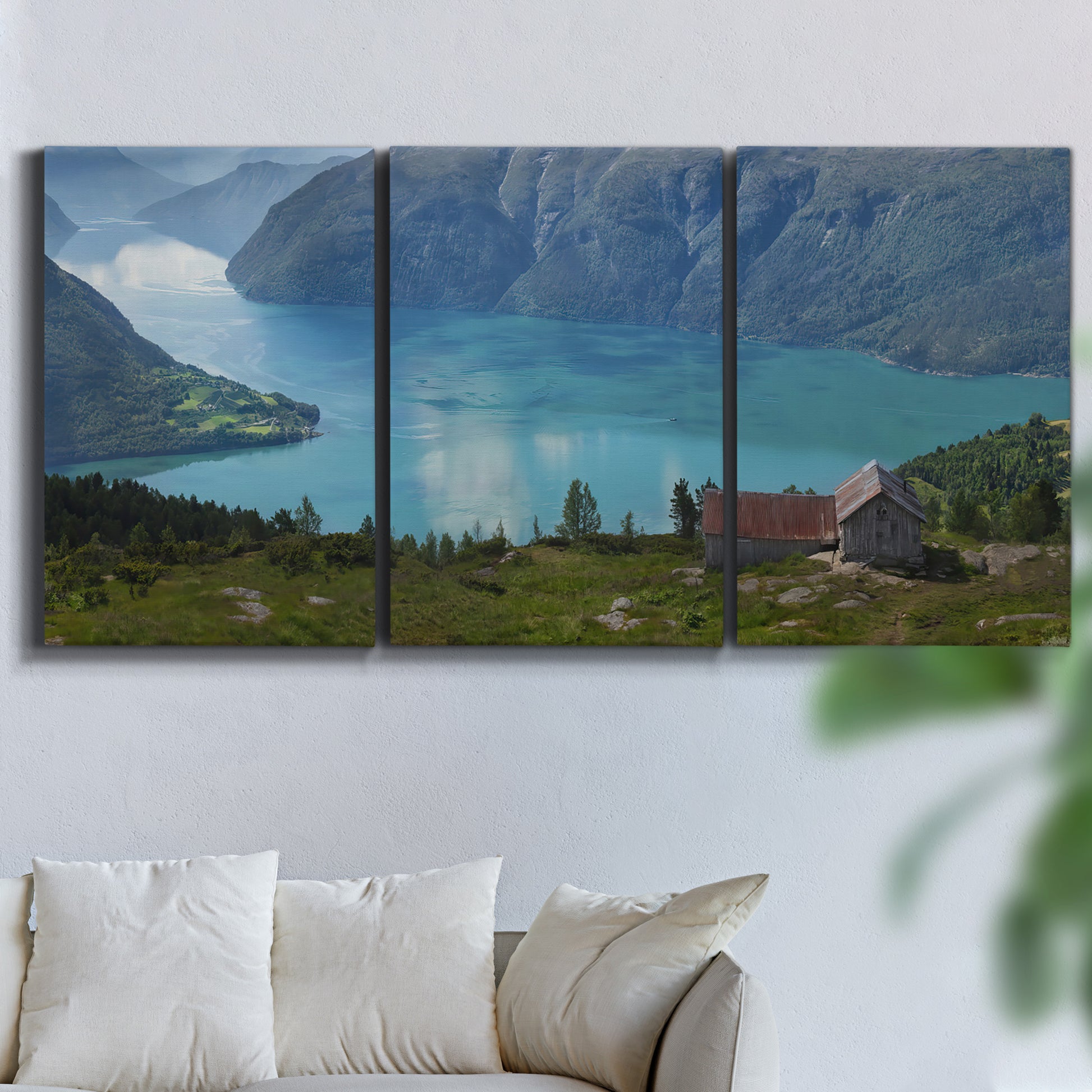Three-panel canvas wall art featuring symmetrical water reflections with trees, displayed in a living room above a sofa.