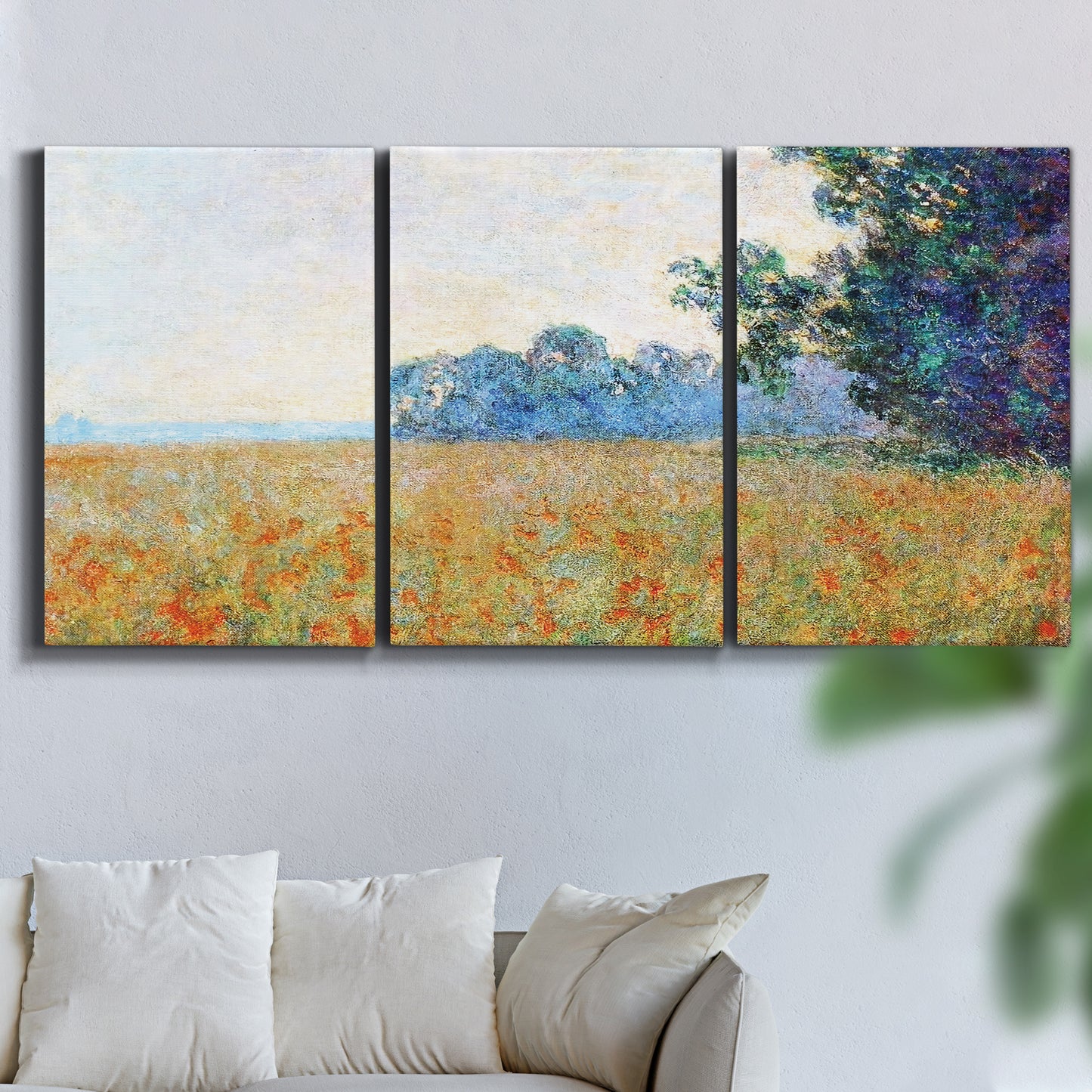 Three-panel canvas wall art featuring oat field with scattered poppies, displayed in a living room above a sofa.