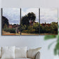 Three-panel canvas wall art featuring garden corner with flowering trees, displayed in a living room above a sofa.