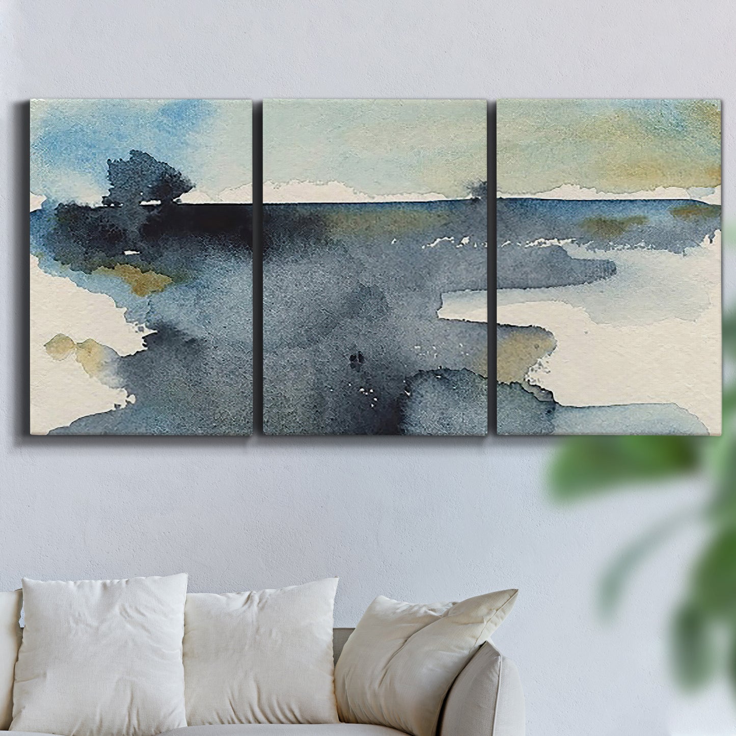 Three-panel canvas wall art featuring abstract watercolor with upward motion, displayed in a living room above a sofa.