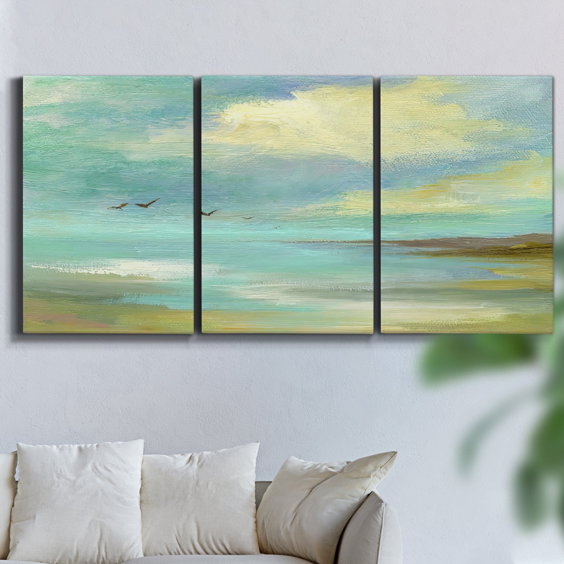Three-panel canvas wall art featuring calm coastal drift patterns, displayed in a living room above a sofa.