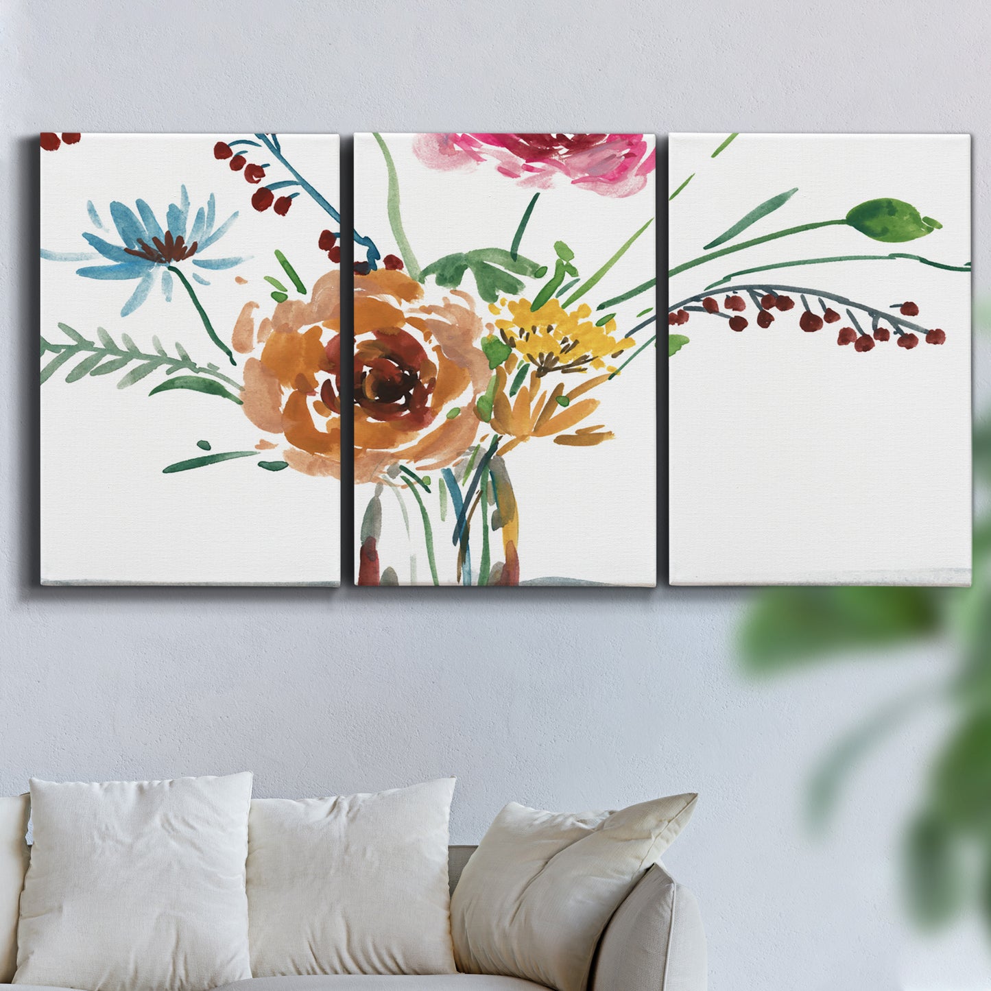 Three-panel canvas wall art featuring vibrant floral bouquet, displayed in a living room above a sofa.