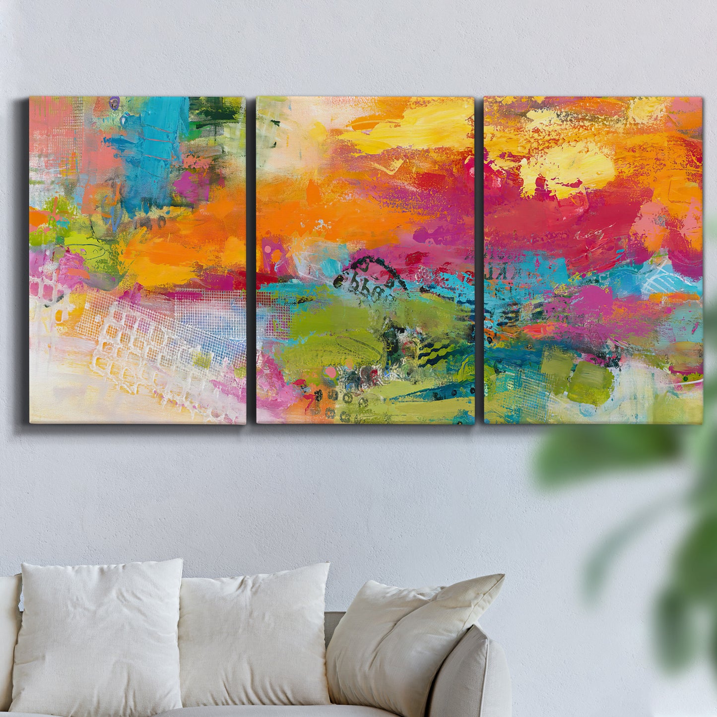 Three-panel canvas wall art featuring expressive abstract sunset tones, displayed in a living room above a sofa.