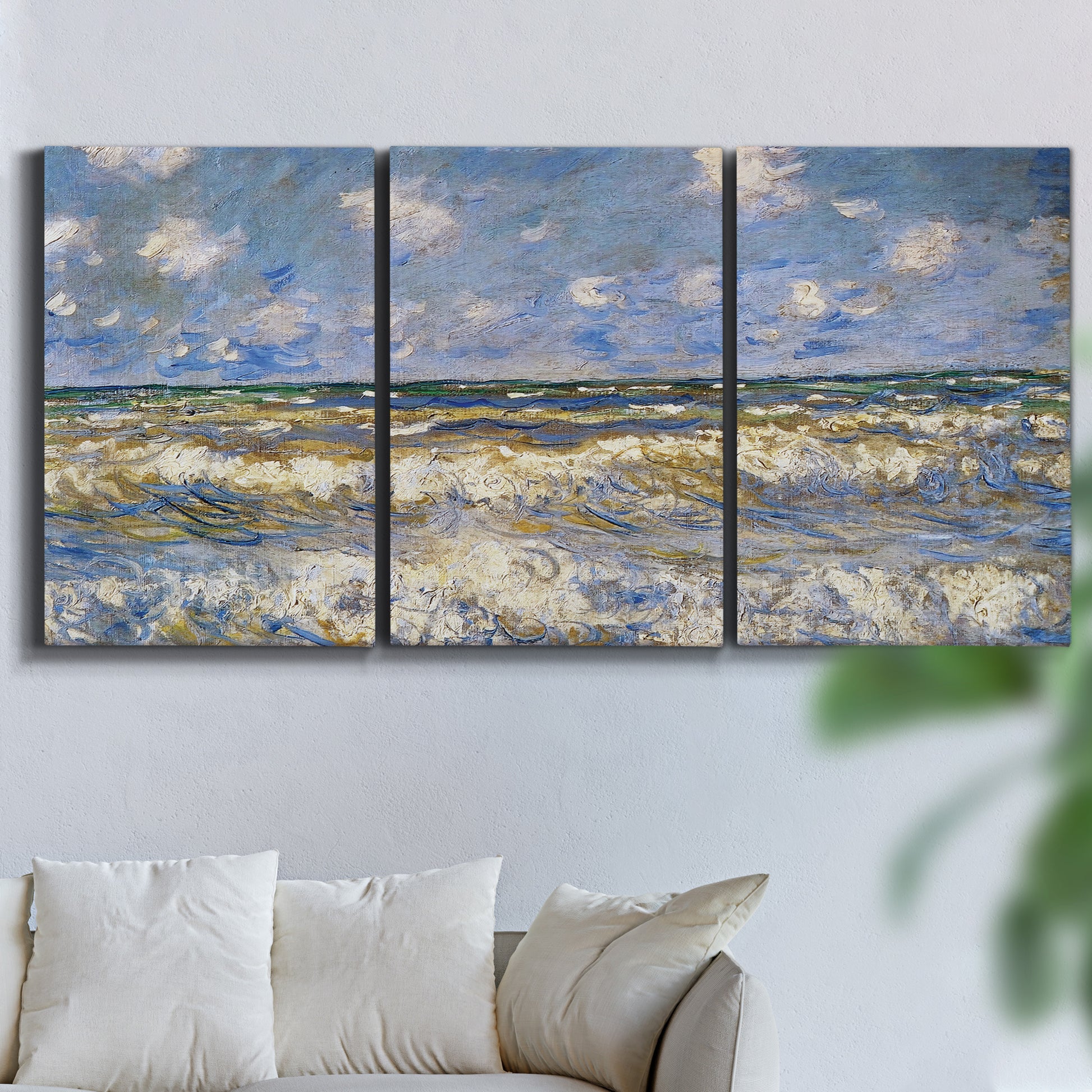 Three-panel canvas wall art featuring rough sea with crashing waves, displayed in a living room above a sofa.