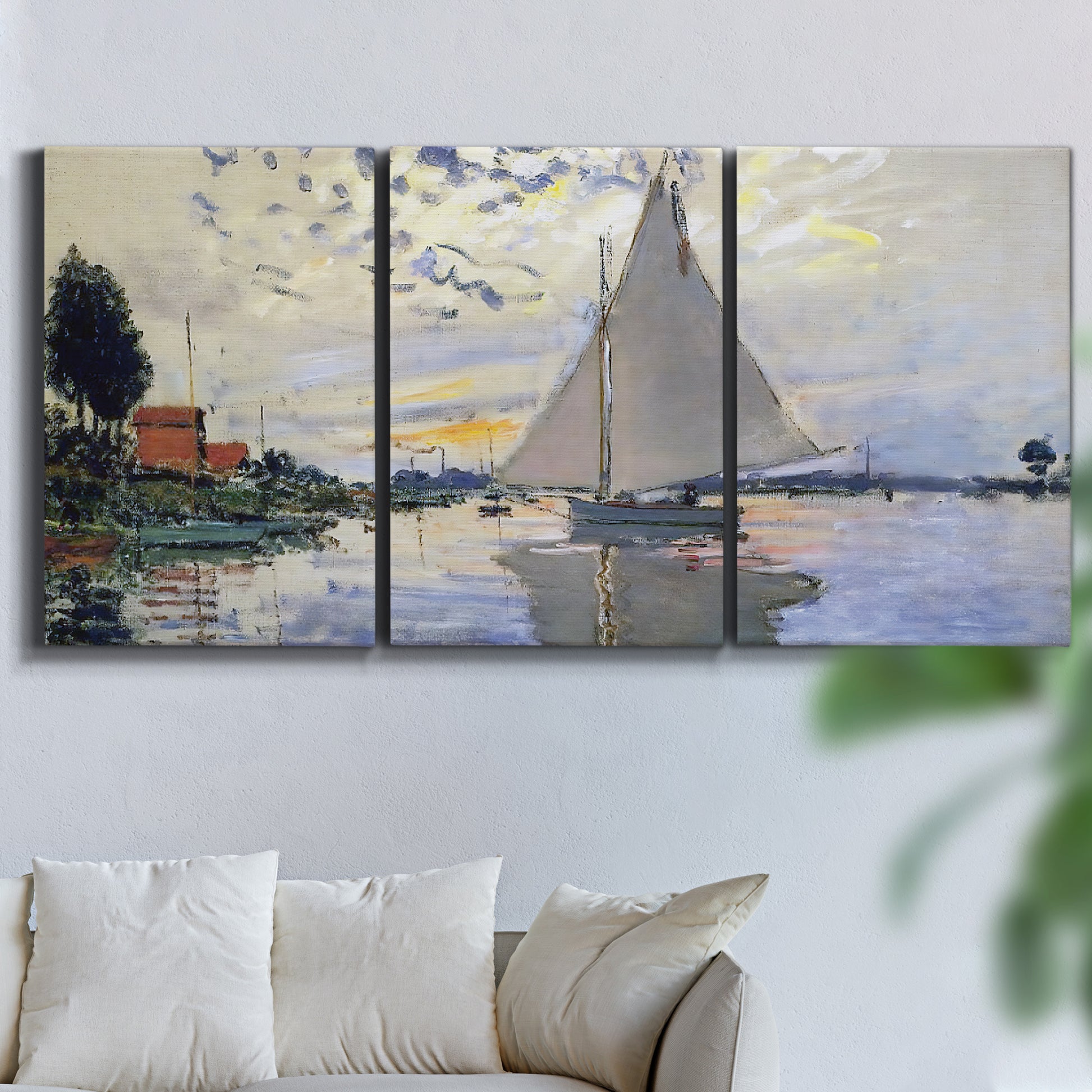 Three-panel canvas wall art featuring riverside village shoreline, displayed in a living room above a sofa.
