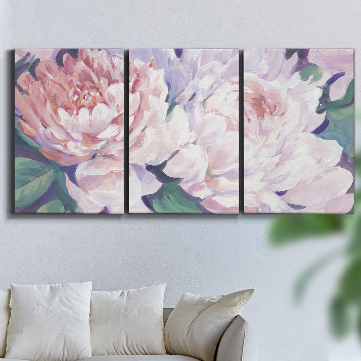 Three-panel canvas wall art featuring soft pink peonies in bloom, displayed in a living room above a sofa.