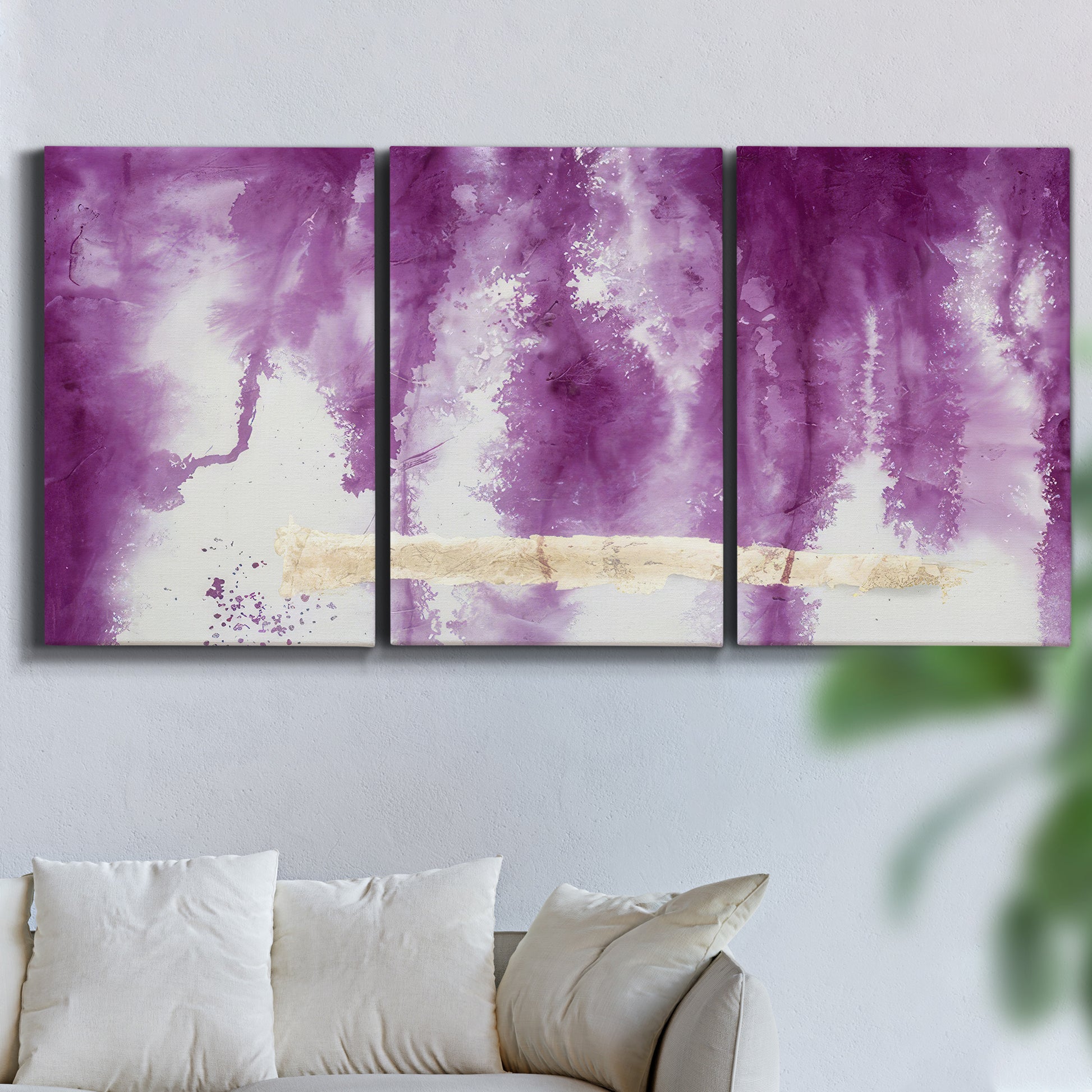 Three-panel canvas wall art featuring saturated abstract color fields, displayed in a living room above a sofa.
