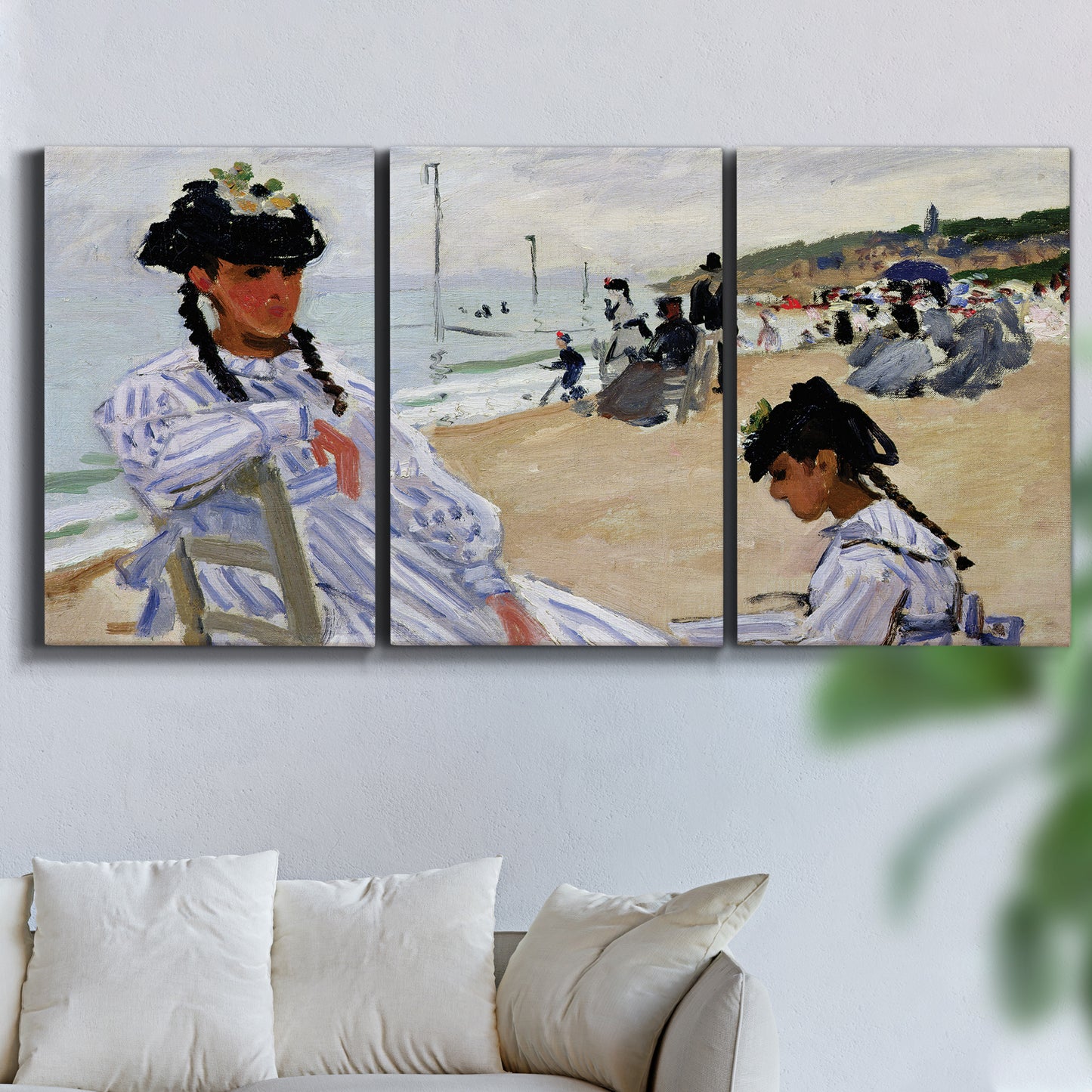 Three-panel canvas wall art featuring figures walking along sandy beach, displayed in a living room above a sofa.
