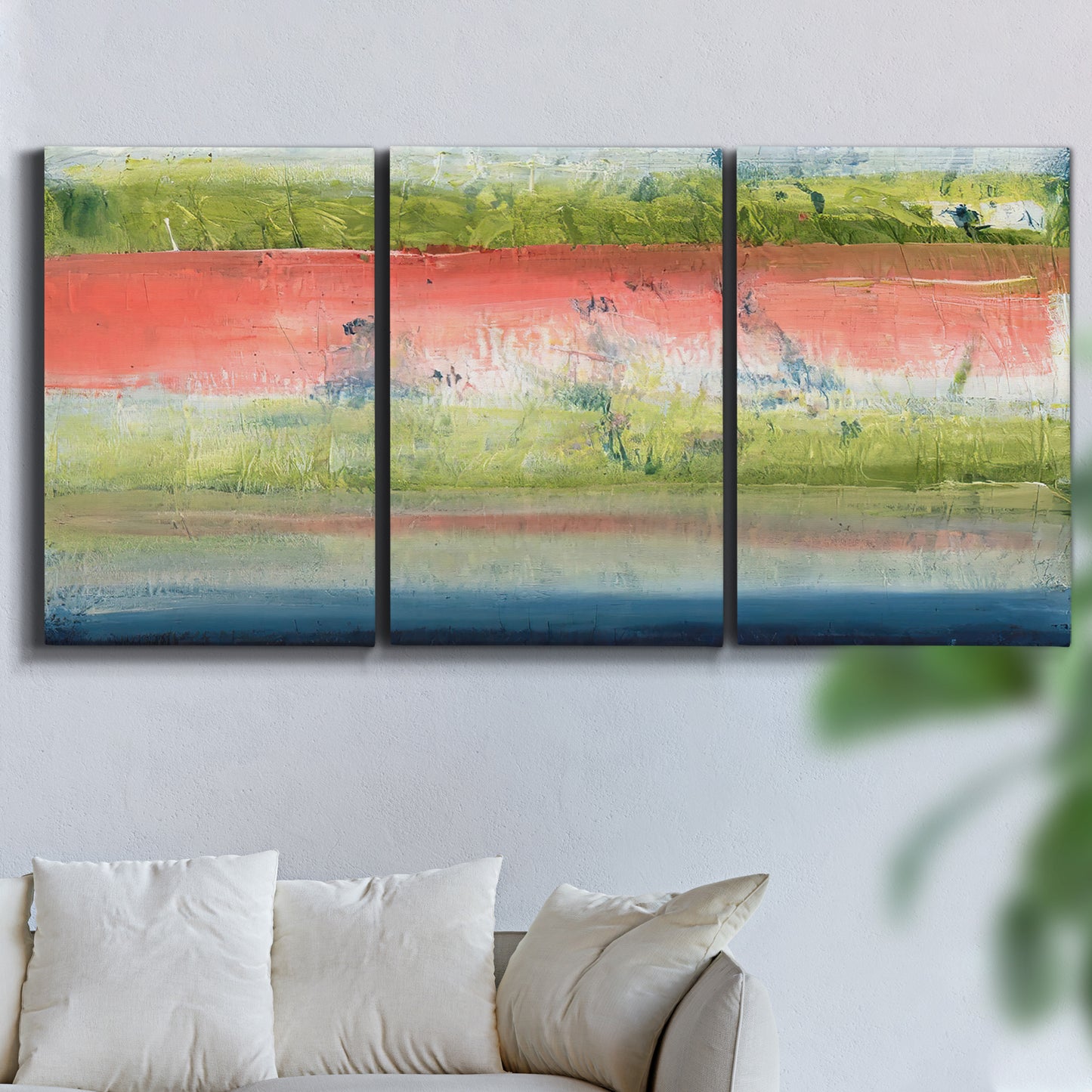 Three-panel canvas wall art featuring layered abstract color banding, displayed in a living room above a sofa.