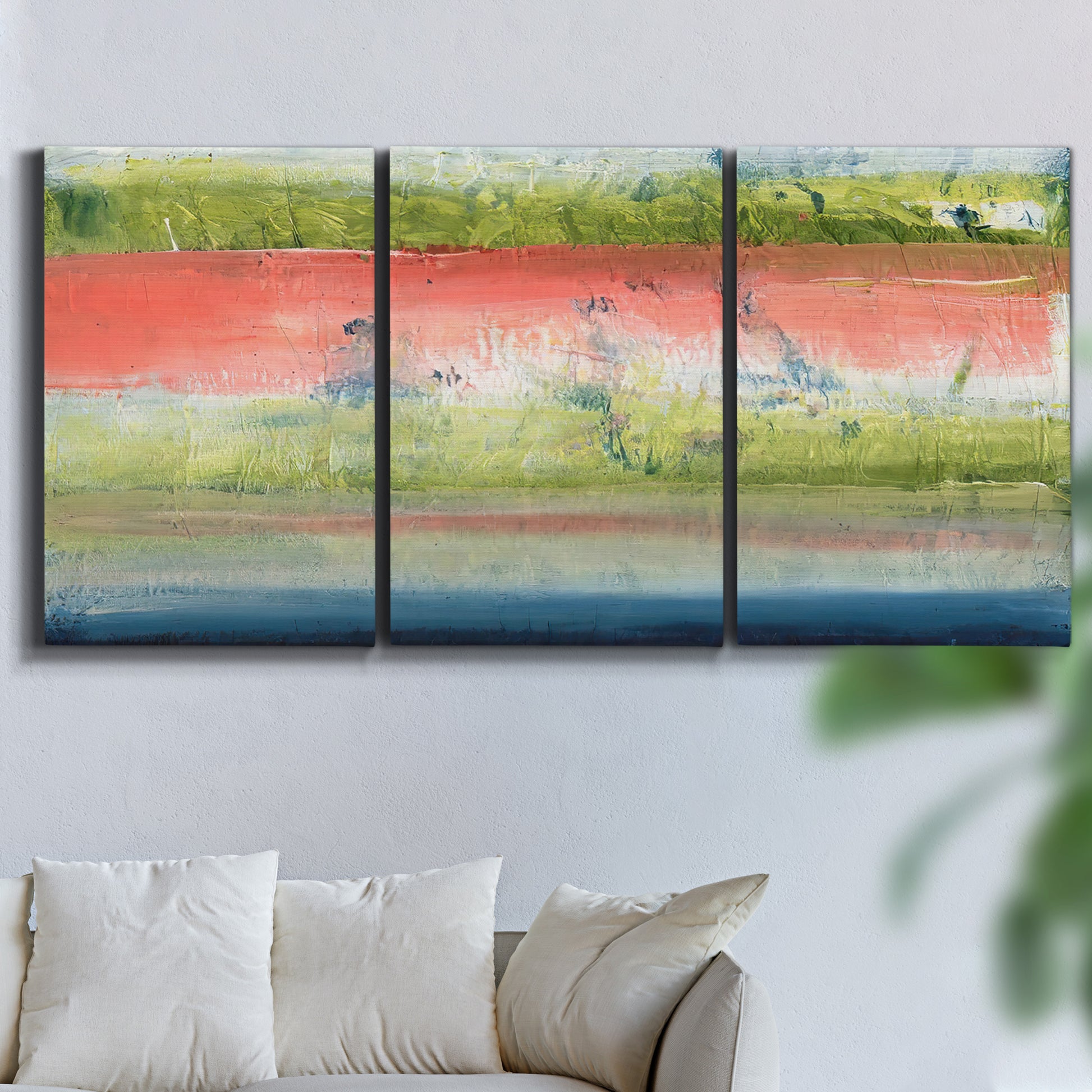 Three-panel canvas wall art featuring layered abstract color banding, displayed in a living room above a sofa.