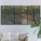 Three-panel canvas wall art featuring spring countryside with fresh foliage, displayed in a living room above a sofa.