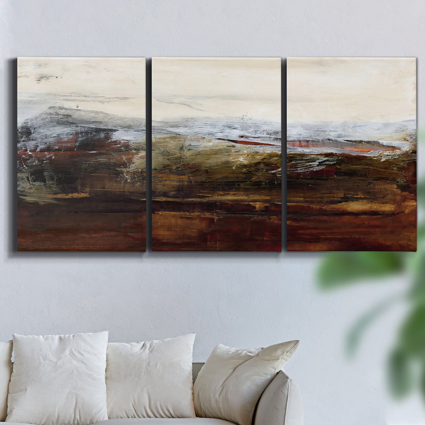 Three-panel canvas wall art featuring rustic abstract landscape exploration, displayed in a living room above a sofa.