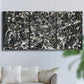 Three-panel canvas wall art featuring energetic expressionist abstract splatter, displayed in a living room above a sofa.