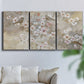 Three-panel canvas wall art featuring early spring blossoms in soft tones, displayed in a living room above a sofa.