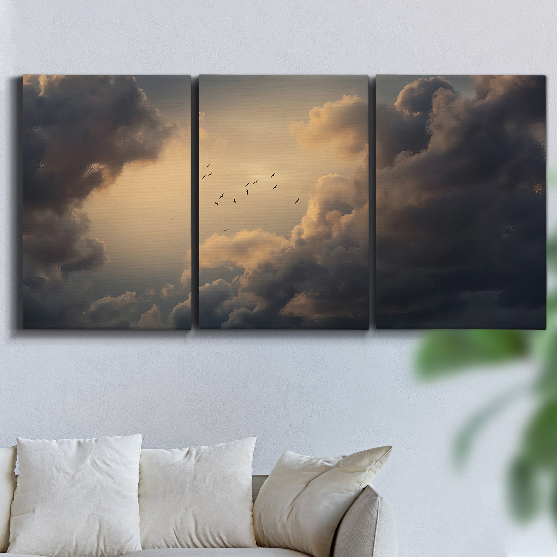 Three-panel canvas wall art featuring surreal floating figures above landscape, displayed in a living room above a sofa.