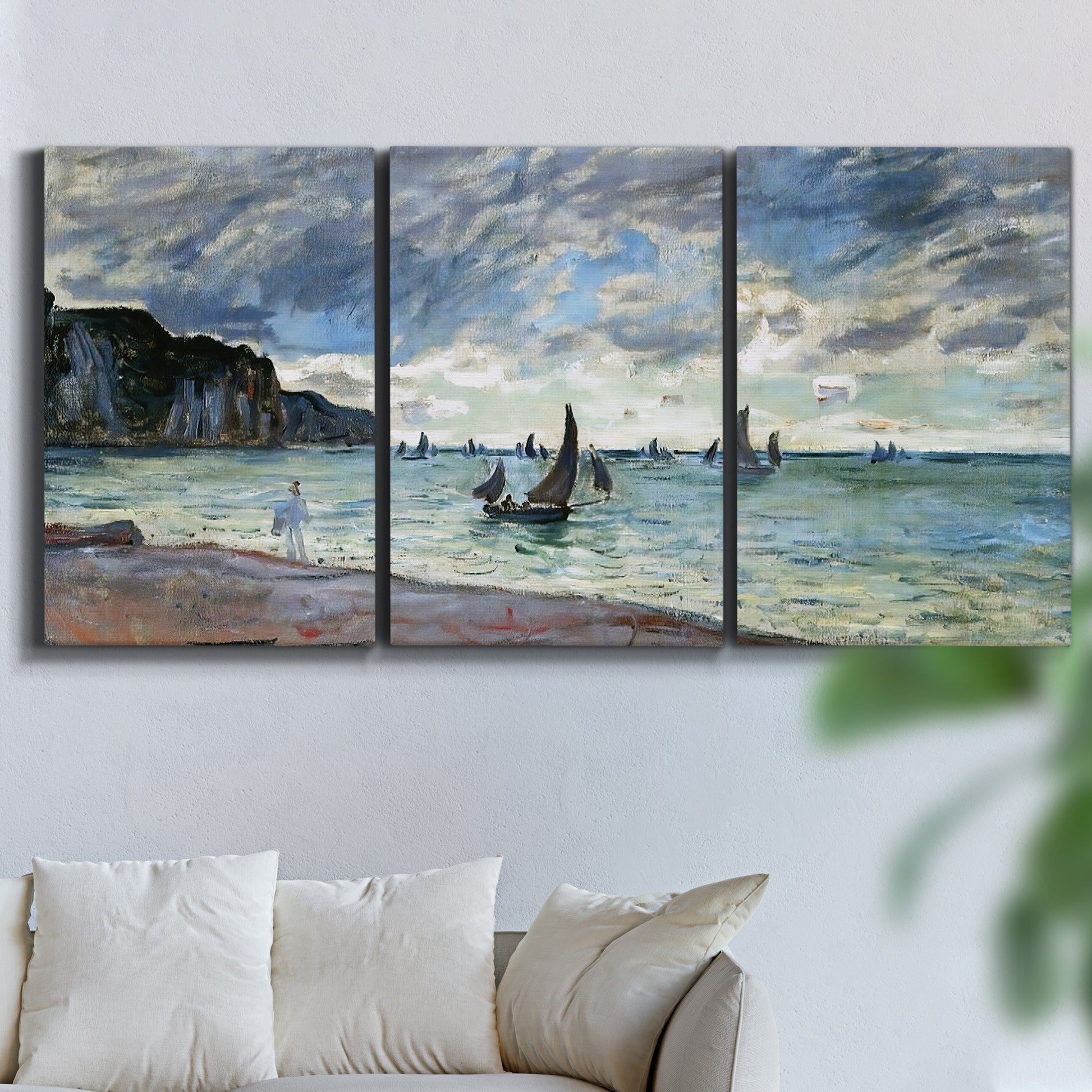 Three-panel canvas wall art featuring figures walking along sandy shoreline, displayed in a living room above a sofa.
