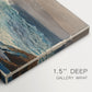 Canvas art print of waves rolling toward rocky shoreline with low buildings nearby, highlighting texture and gallery-wrapped edges